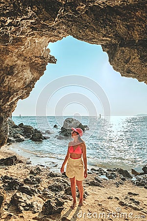 Women standing on a rock at the cave entrance Look at the sea and beautiful views. at sunset romantic atmosphere at Kho Larn , Stock Photo