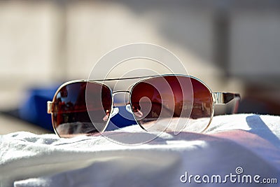 Women sunglasses lie on a beach towel. Stock Photo