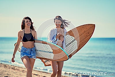 Women surfers walking on the beach and having fun in summer Vacation. Extreme Sport. Stock Photo