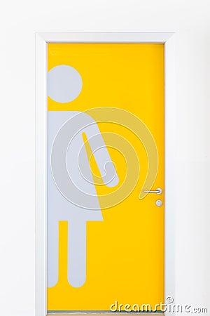 Women symbols on yellow public toilet entrance door. Stock Photo