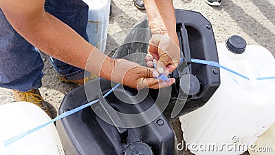 Women ties gasoline containers Stock Photo