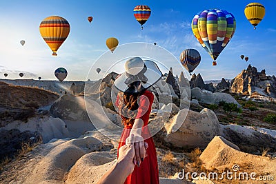 Women tourists holding man`s hand and leading him to hot air balloons in Cappadocia, Turkey. Stock Photo