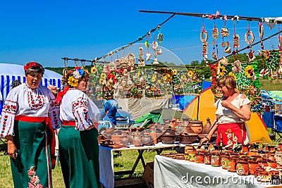 Women in traditional ukrainian clothing buying clay pottery ceramic in market during ethno-rock festival Kozak Fest Editorial Stock Photo