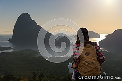Women traveler with backpack checks map to find directions Stock Photo