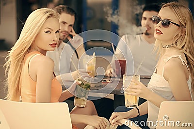 Women twins and men friends relax in cafe outdoor Stock Photo