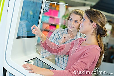 2 women using interactive kiosk Stock Photo