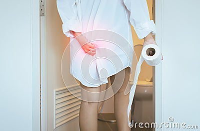 Women using toilet and suffers from Diarrhea and Hemorrhoids after wake up in morning at house Stock Photo