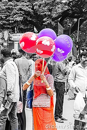 A women wear red saree selling a bunch of baloon Editorial Stock Photo