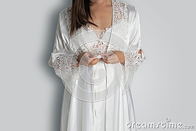 Women wearing white nightgown & long sleeve satin robe with floral lace Stock Photo