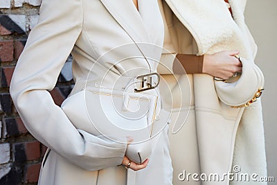 Women with white Fendi coat and bags with golden details before Fendi fashion show, Milan Editorial Stock Photo