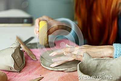 Women& x27;s hands knead the clay and sculpt a cup or bowl from it. The process of manufacturing a ceramic product,close Stock Photo