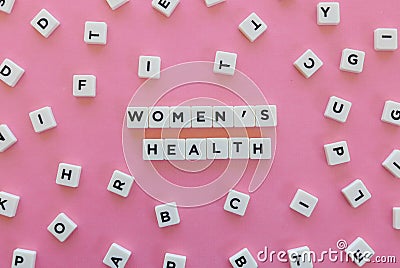 Women& x27;s Health word made of square letter word on pink background. Stock Photo