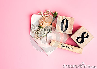 Womens day composition. 8 march wooden calendar with flowers in an envelope on the pink background. Copy space, top view Stock Photo