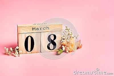 Womens day concept. 8 march wooden calendar with flowers on the pink background. Copy space, close up, minimalism Stock Photo