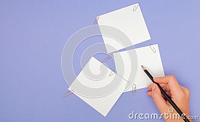 Womens hand writing on note papers on purple background. Blanks sheet of papers and color pencils on violet background. copy space Stock Photo