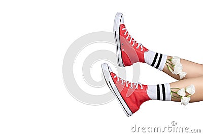 Womens legs in stylish red sneakers and white socks with flowers Stock Photo