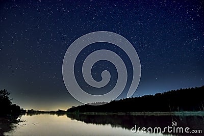 Wonderful beautiful night sky full of stars with Milky way over the river and forest in transparent april night Stock Photo