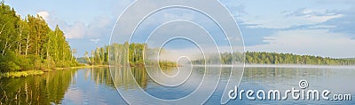 A wonderful evening in fog on the lake, pink clouds in the sky are reflected with trees from the water surface Stock Photo