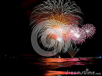 Wonderful fireworks lighting ocean`s water Stock Photo