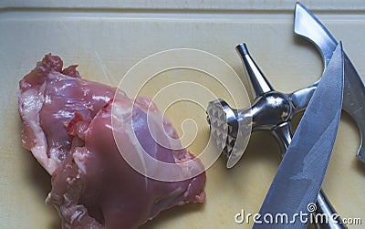 The wonderful fresh piece of chicken meat and meat hammer and kn Stock Photo