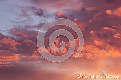Wonderful golden, purple and pink fluffy clouds in blue sky as abstract background, texture. Stock Photo