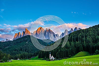 Wonderful landscape of Dolomite Alps during sunset. St Johann Church, Santa Maddalena, Val Di Funes, Dolomites, Italy. Amazing Stock Photo