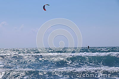 Wonderful morning day, ideal time for some activity. In the distance Kiteboarder sails on surfboard and gaining speed thanks to Stock Photo