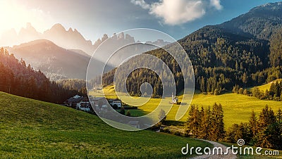 Wonderful nature Landscape. The greenery hills and small village with Alpine Mountain in background Val di Funes Stock Photo