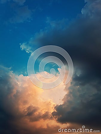 Wonderful storm clouds sunlit with a golden light like coming out of heaven. Dreamlike sky, vertical celestial background Stock Photo