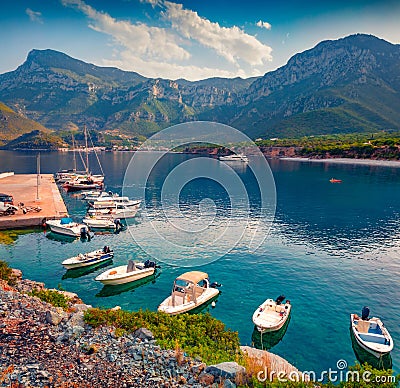 Wonderful summer view of Logari port with small fishing boat and Kyparissi village on background. Stock Photo