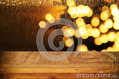 wood board table in front of Christmas warm gold garland lights on wooden rustic background Stock Photo