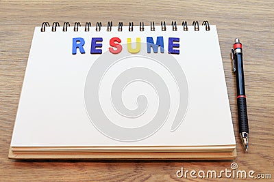 Wood colorful letter word resume lay down notebook on wood background with pencil Stock Photo