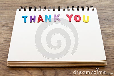 Wood colorful letter word THANK YOU lay down notebook on wood ba Stock Photo