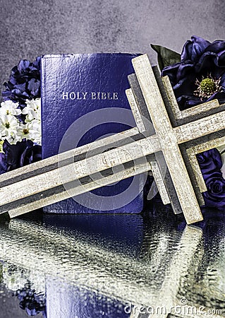 Blue bible and wooden cross on wet mirror Stock Photo