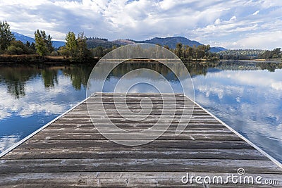 Wood dock by calm river. Stock Photo