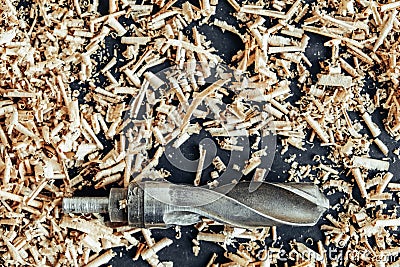 Wood drill bit with wooden shavings on black background. Copy, empty space for text Stock Photo