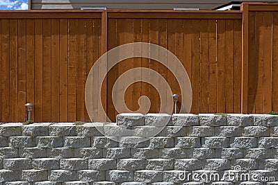 Wood Fencing on Cement Stack Stone Retaining Wall Stock Photo