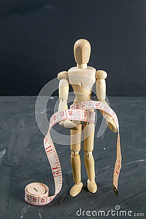 Wood Figure Mannequin with measuring tape, dieting Concept Stock Photo