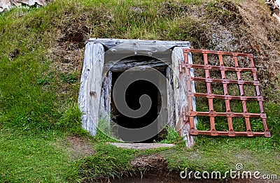 Underground Wooden Framed Doorway With Open Rusted Metal Gate Stock Photo