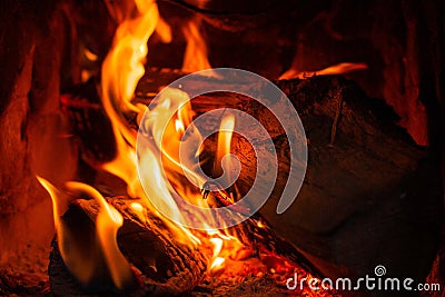 Wood log burning in the chimenea. Fire wood, coal and amber ash closeup. Stock Photo