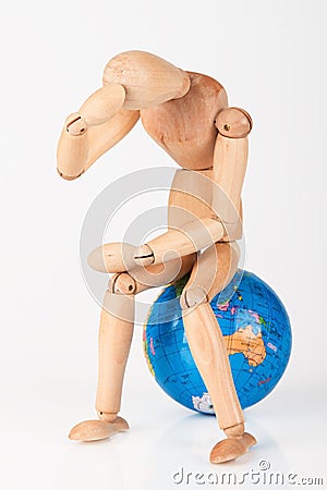 Wood mannequin sitting on top of a globe Stock Photo