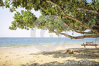 Wood number 2017 on wooden swing on tropical beach background Stock Photo