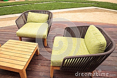 Wood patio lounge chairs with green cushions Stock Photo