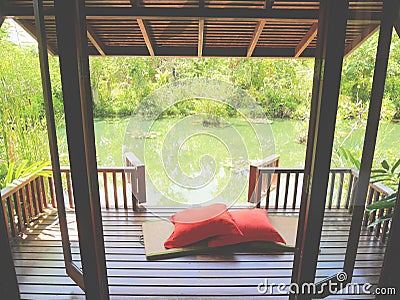 Wood patio on a relaxing green pond with bamboo mat and pillows Stock Photo