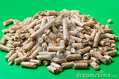 Wood pellets on a green background , copy space. Biofuels. Stock Photo