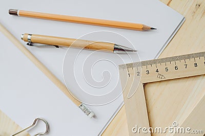 Wood pencil, pen, triangle, briefpapier clip on the desk in daylight. Office table Stock Photo