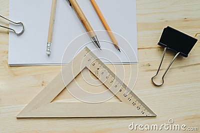 Wood pencil, pen, triangle, briefpapier clip on the desk in daylight. Office table Stock Photo