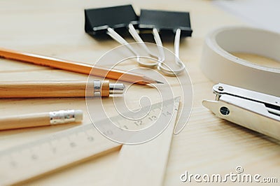 Wood pencil, pen, triangle, briefpapier clips, hefter on the desk in daylight. Office table Stock Photo