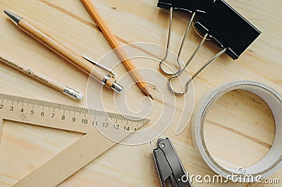 Wood pencil, pen, triangle, briefpapier clips, hefter on the desk in daylight. Office table Stock Photo