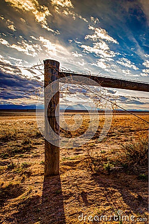 Wood Post Barbed Wire Fence on Prairie Stock Photo